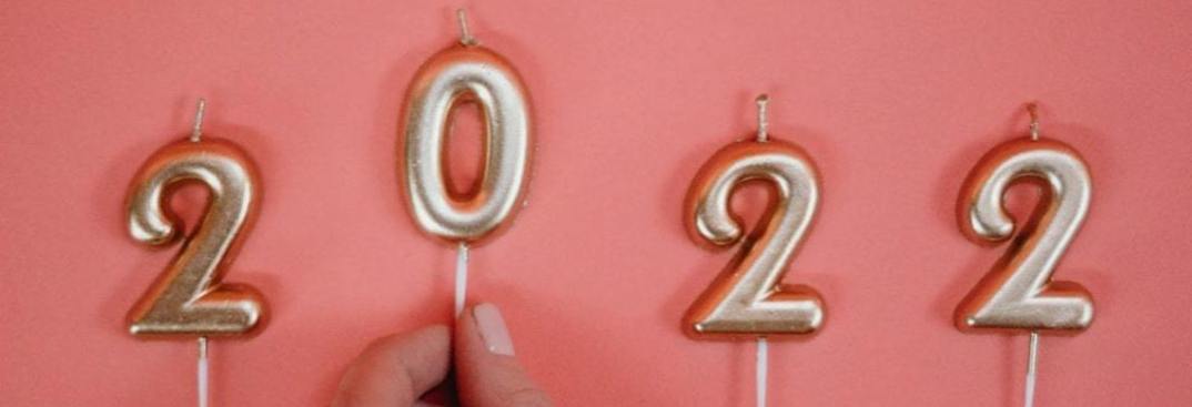 2022 in gold cake candles on a pink background